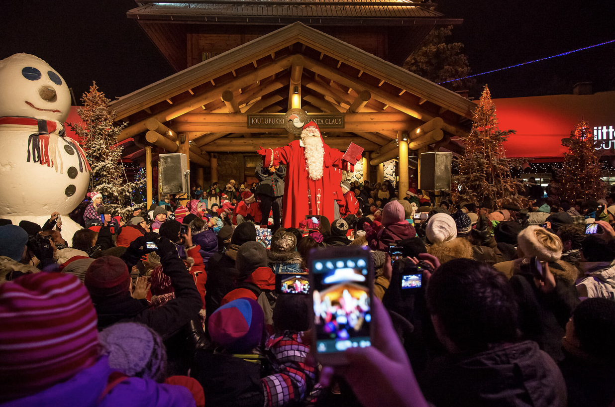 Santa Claus recibe a los visitantes en su casa en el corazón del Polo Norte, rodeado de un paisaje invernal.